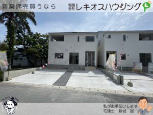 白い外壁の新築2階建て住宅の外観とコンクリートの駐車スペース