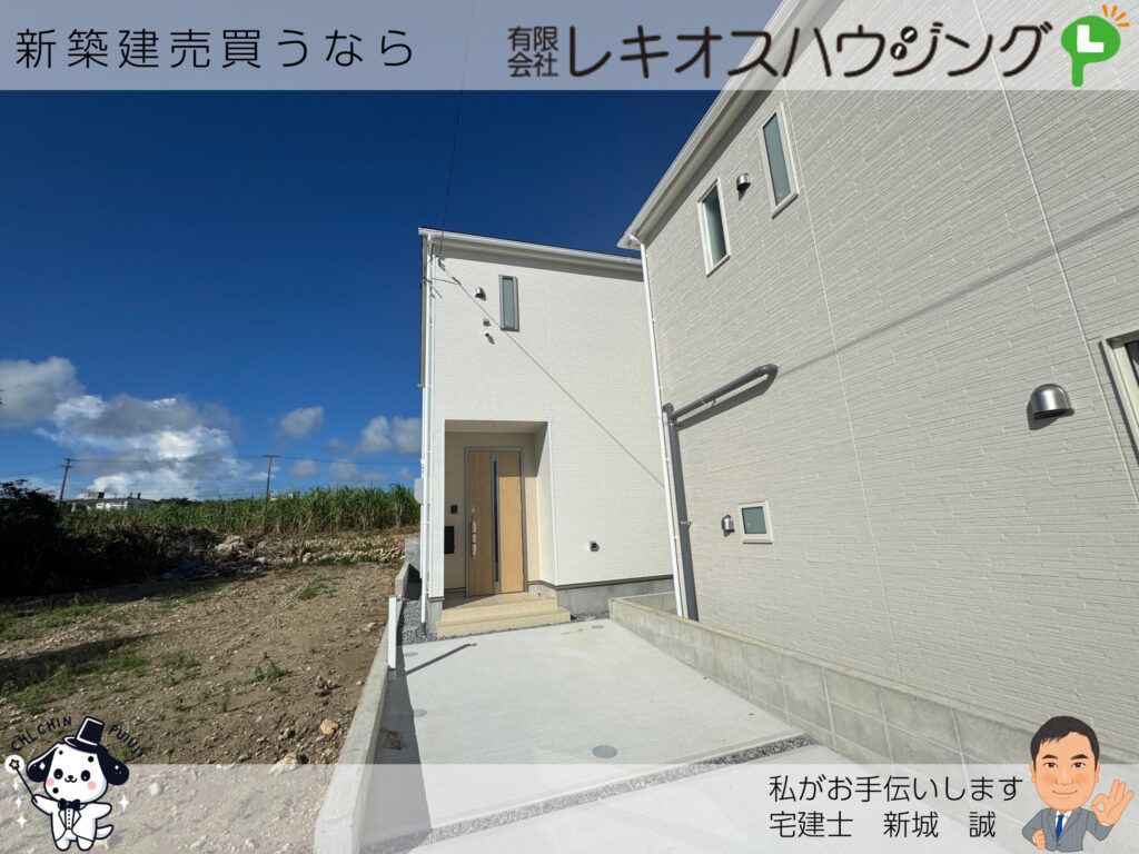 白いタイル調外壁の新築2階建て住宅と玄関前の駐車スペース