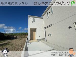白いタイル調外壁の新築2階建て住宅と玄関前の駐車スペース