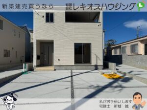 白い外壁の2階建て外観。玄関ポーチと大きな掃き出し窓