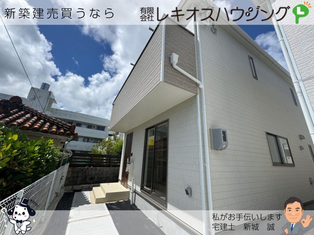 白い外壁の建物を斜めから見た外観。窓に1号棟の表示