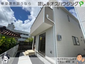 白い外壁の建物を斜めから見た外観。窓に1号棟の表示