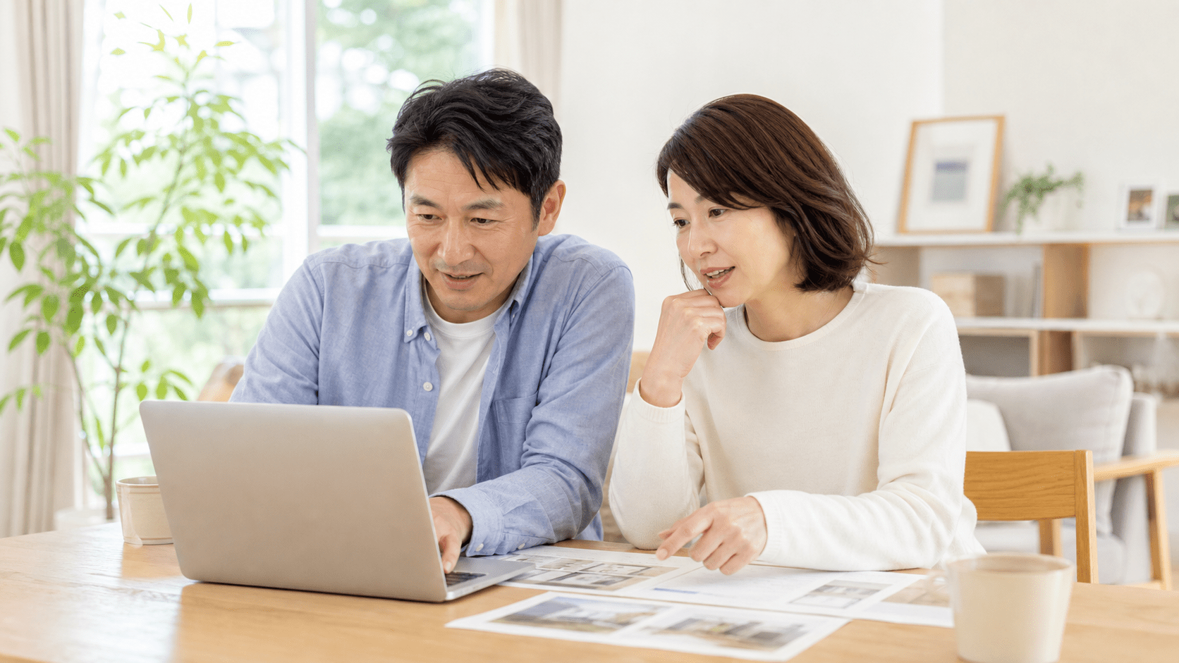 ノートパソコンと資料を見ながら相談する夫婦