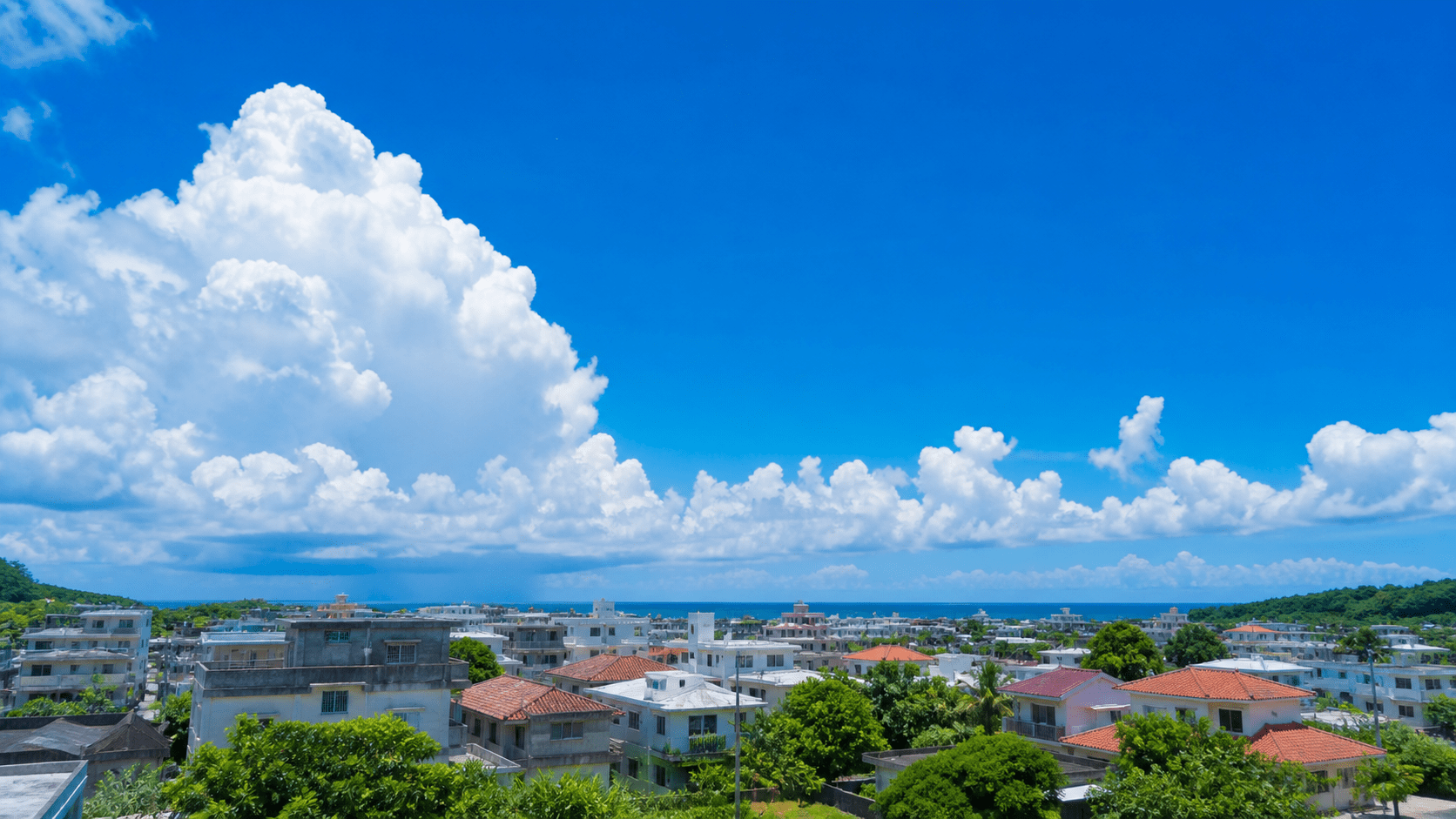 沖縄の住宅街の上に広がる夏の入道雲