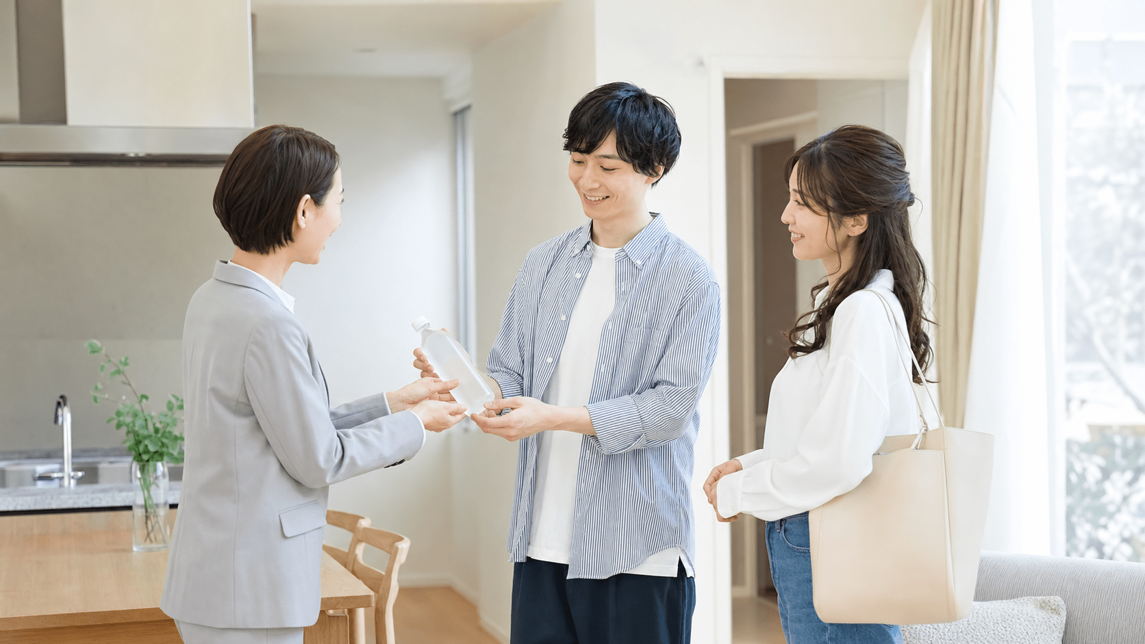 内覧中にスタッフからドリンクを受け取る夫婦