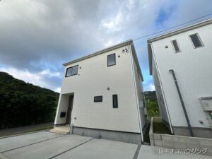 2階建ての白い外壁の外観です。隣の住宅との位置関係が分かります